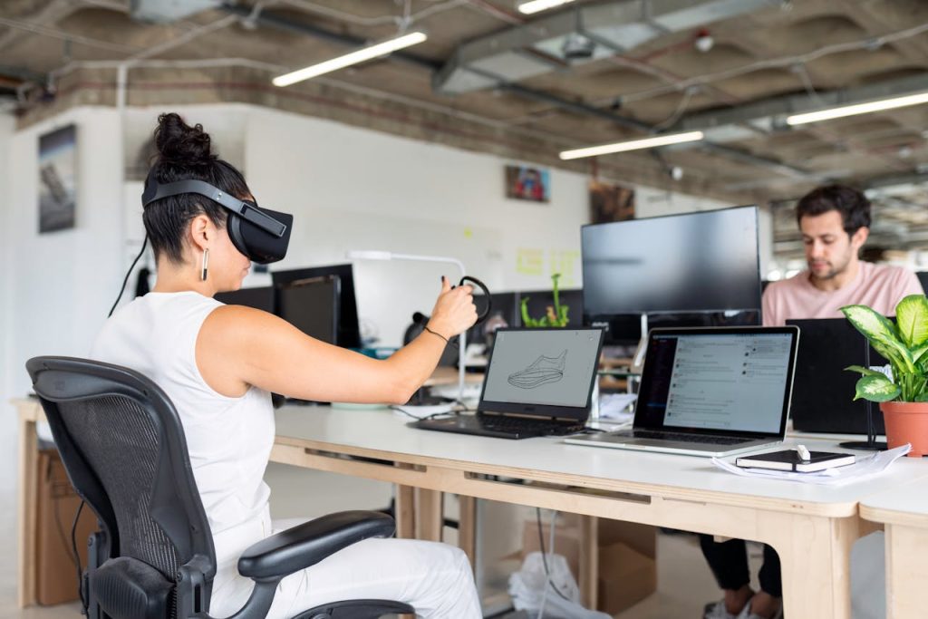 Woman Using Laptop Computer With VR Headset